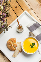 Sopa crema de calabaza zapallo en una bandeja blanca con pan. Vista superior