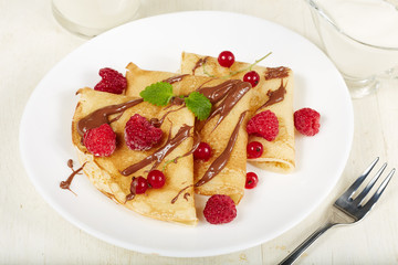 Pancakes with raspberry, red currant and chocolate. Dessert. Traditional Russian cuisine.