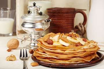 Pancakes with banana, nuts and honey. Traditional Russian cuisine. Maslenitsa. Dessert.