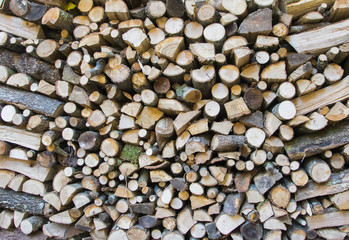 Wall firewood , background of dry chopped firewood logs in a pile.