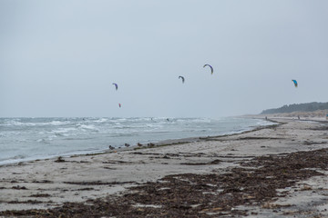 Kitesurfing vid en blåsig sandstrand