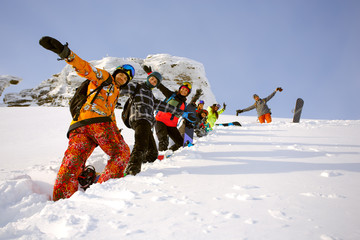 Group of friends snowboarders having fun on the top of mountain
