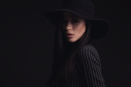 Beautiful woman wearing retro hat and black striped shirt. fashion studio shoot.