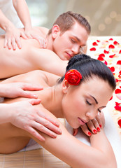 Couple lying  in a spa salon enjoying back massage.