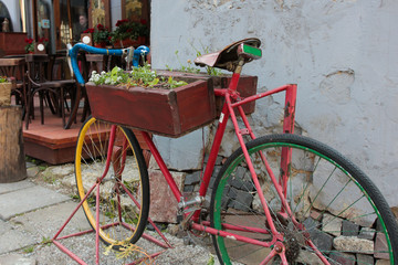 Fototapeta na wymiar Old bicycle as decoration in cafe. Bicycle with flowers. Exterio