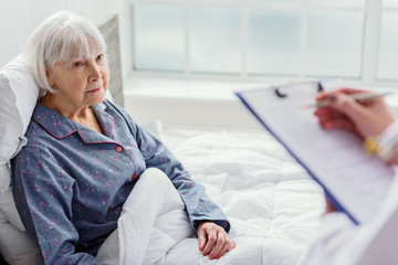 Physician questioning old woman in hospital