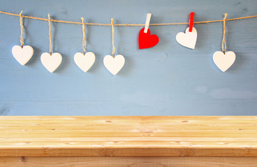 hearts hanging in front of wooden background