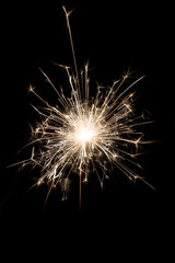 A burning sparkler on a black background