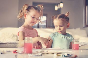 Little girl painting with tempura.