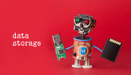 Data storage concept. Robot toy with usb flash stick and memory card on red background. Copy space macro view photo