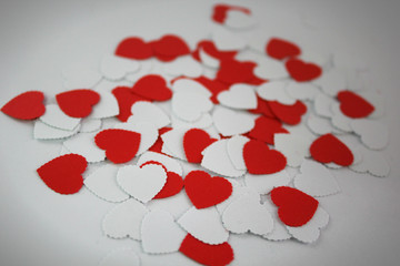 white and red paper hearts on white background