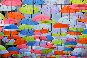 Fototapeta na wymiar Bright colorful umbrellas as street decoration hanging up in the open air