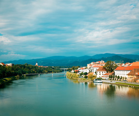 Maribor Old Town View and Drava River on Mountains Background. Popular Touristic Destination in Slovenia, Europe. Beautiful Slovenian Landscape. Copy Space. - 136045284