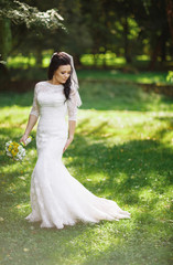 Beautiful bride in the dress in the bright park