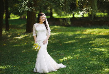 Obraz na płótnie Canvas Gorgeous bride in the fresh green park