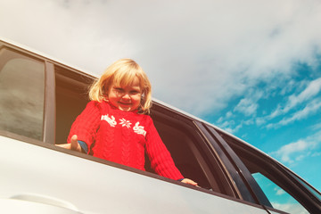 happy little girl travel by car at sky