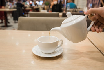Teapot and cup of tea in cafe