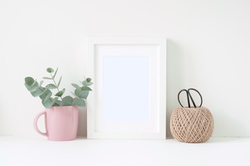 Styled composition with white frame and pink ranunculos