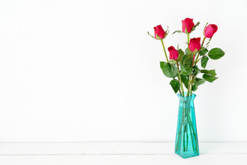Red roses flower bouquet in green vase on white background