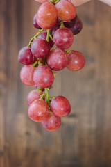 Bunch of grapes over the wooden background.