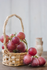 Grapes on basket over the wooden background