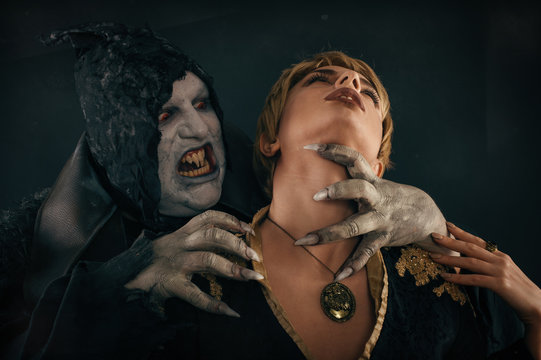 Ancient monster vampire demon bites a woman neck. Halloween fant