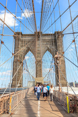 Fototapeta premium Traveling people at Brooklyn Bridge in New York City on clear su
