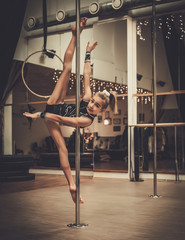 Cute little girl performing pole dance on pole
