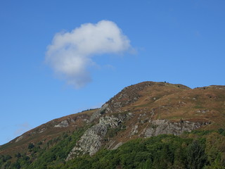 Fototapeta na wymiar Single cloud above hill summit