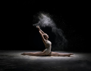 Fototapeta na wymiar Dancer sitting on stage in cloud of powder