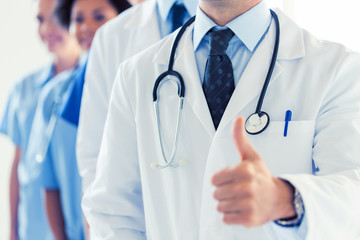close up of happy doctor showing thumbs 
