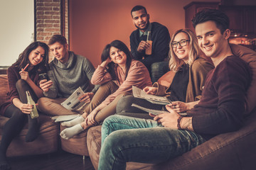 Group of multi ethnic young students preparing for exams in home interior