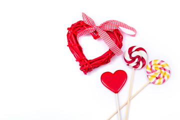 Gift for Valentines day. Red wooden heart and different lollipops on the white background. 