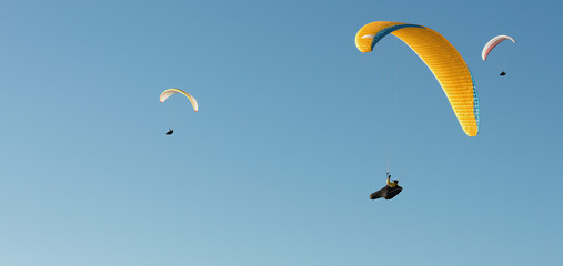 Group of paragliding flying in the blue sky