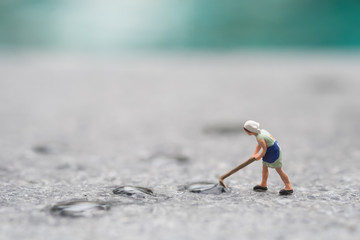 Miniature people mop the wet floor