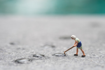 Naklejka premium Miniature people mop the wet floor