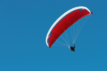 Paraglider flying in a beautiful blue sky