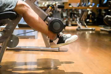 Fototapeta na wymiar Leg extension exercise man at gym indoor workout