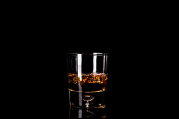 Glass of whiskey isolated on black background