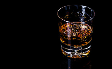 Glass of whiskey isolated on black background