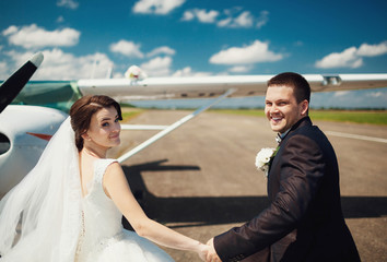 beautiful and young newlyweds walking near helicopter