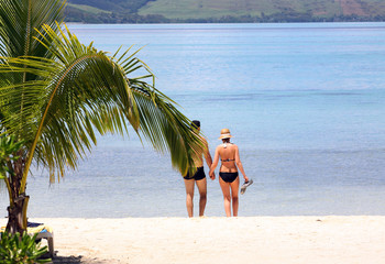 Ein Paar geht zusammen baden am Strand von Mauritius