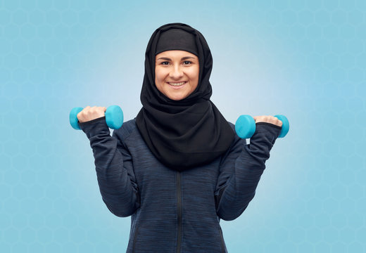 Muslim Woman In Hijab With Dumbbells Doing Fitness