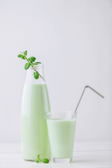 Milk cocktail with mint on a rustic white table