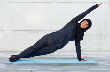 muslim woman doing sport on mat