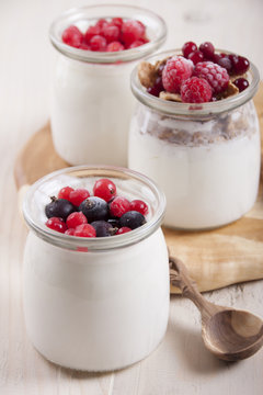 Homemade yogurt with berries in three banks