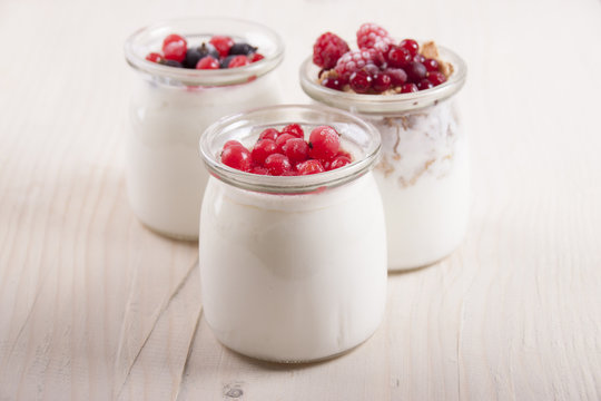 Homemade yogurt with berries in three banks