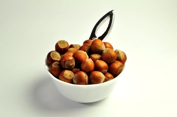 hazelnuts in a white plate with nutcracker