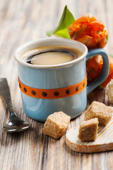 Blue ceramic cup of black hot coffee with brown sugar