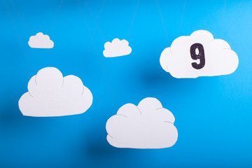 On cloud nine concept with white fluffy clouds hanging infront of blue sky background